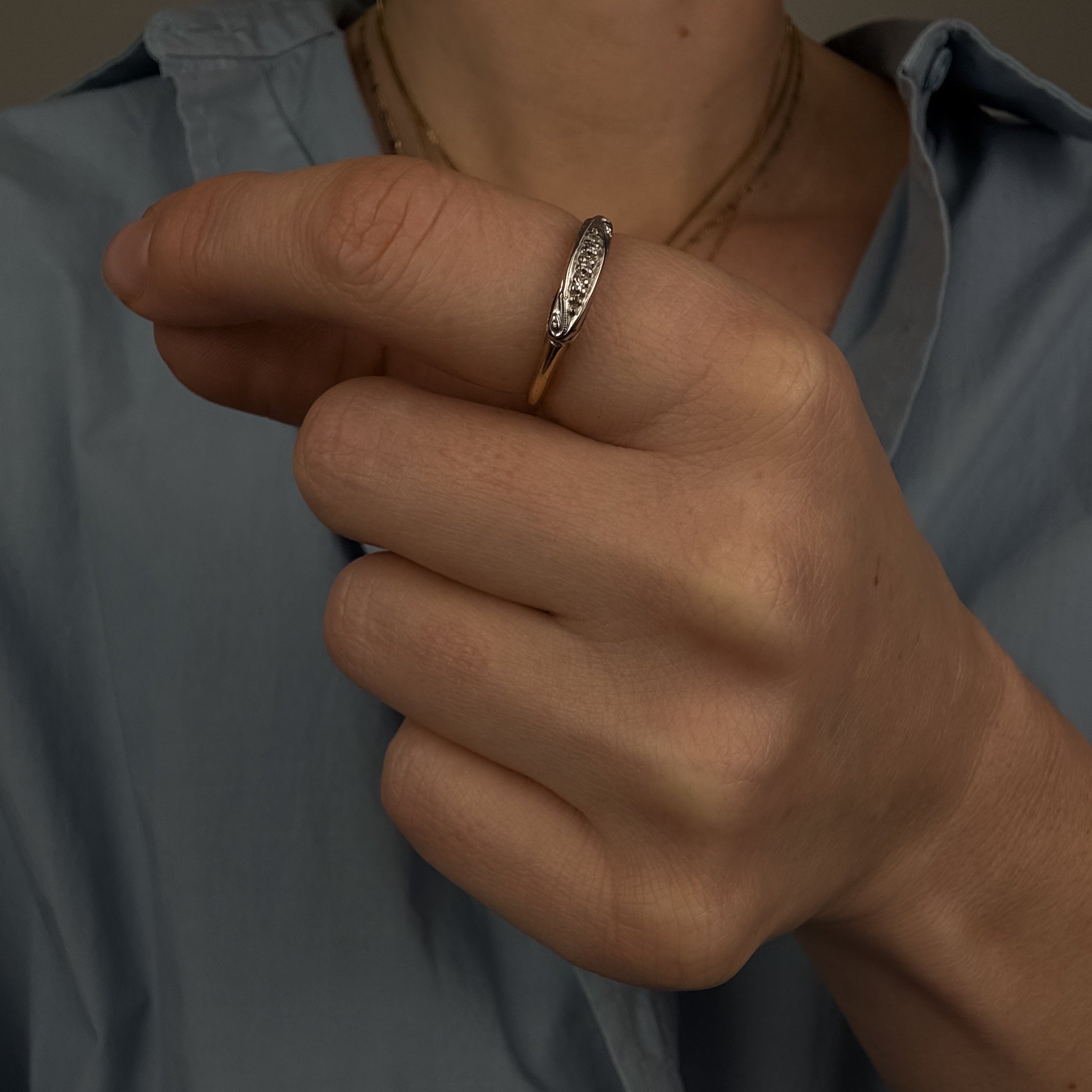 Close-up of a hand wearing a ring with a blurred background