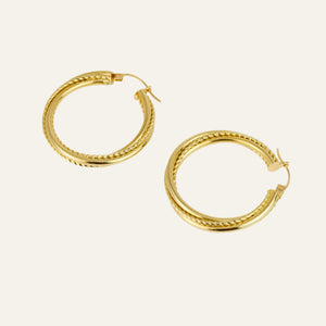 Gold hoop earrings on a light beige background