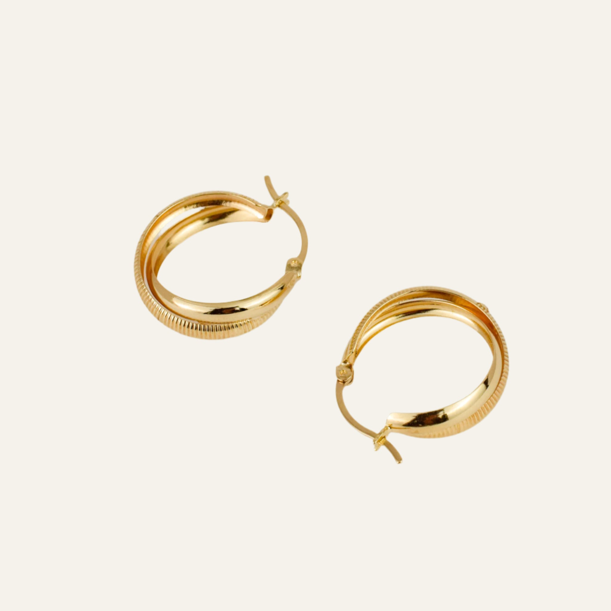 Gold hoop earrings on a light gray background
