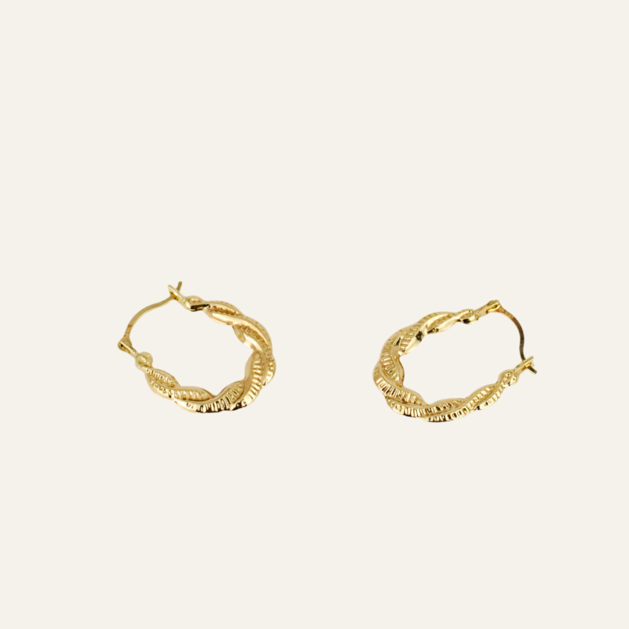 Gold hoop earrings on a light gray background