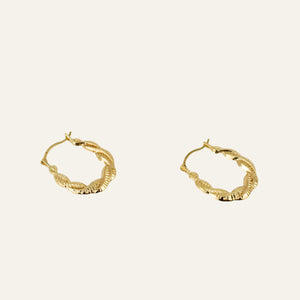 Gold hoop earrings on a light gray background