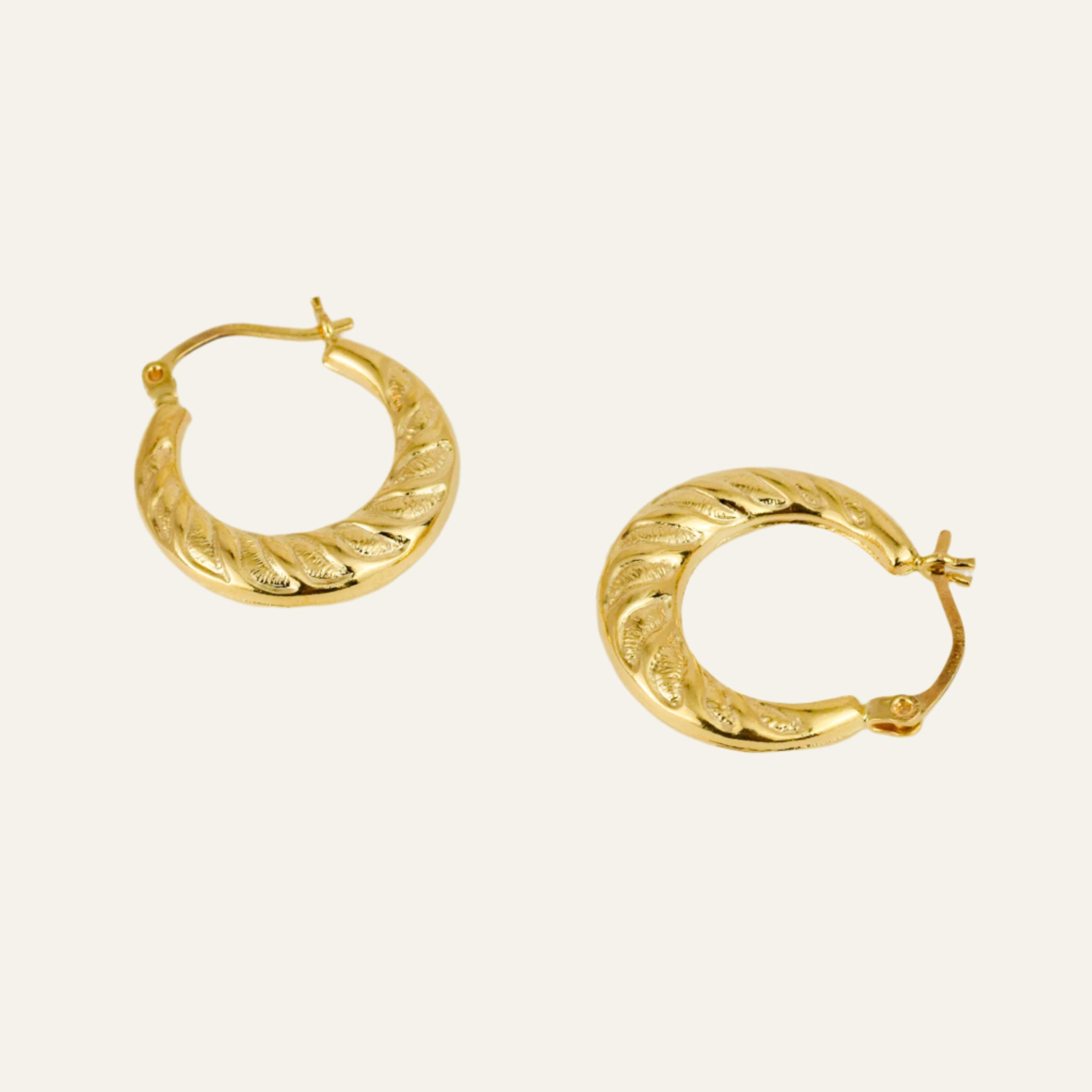 Gold hoop earrings on a light gray background