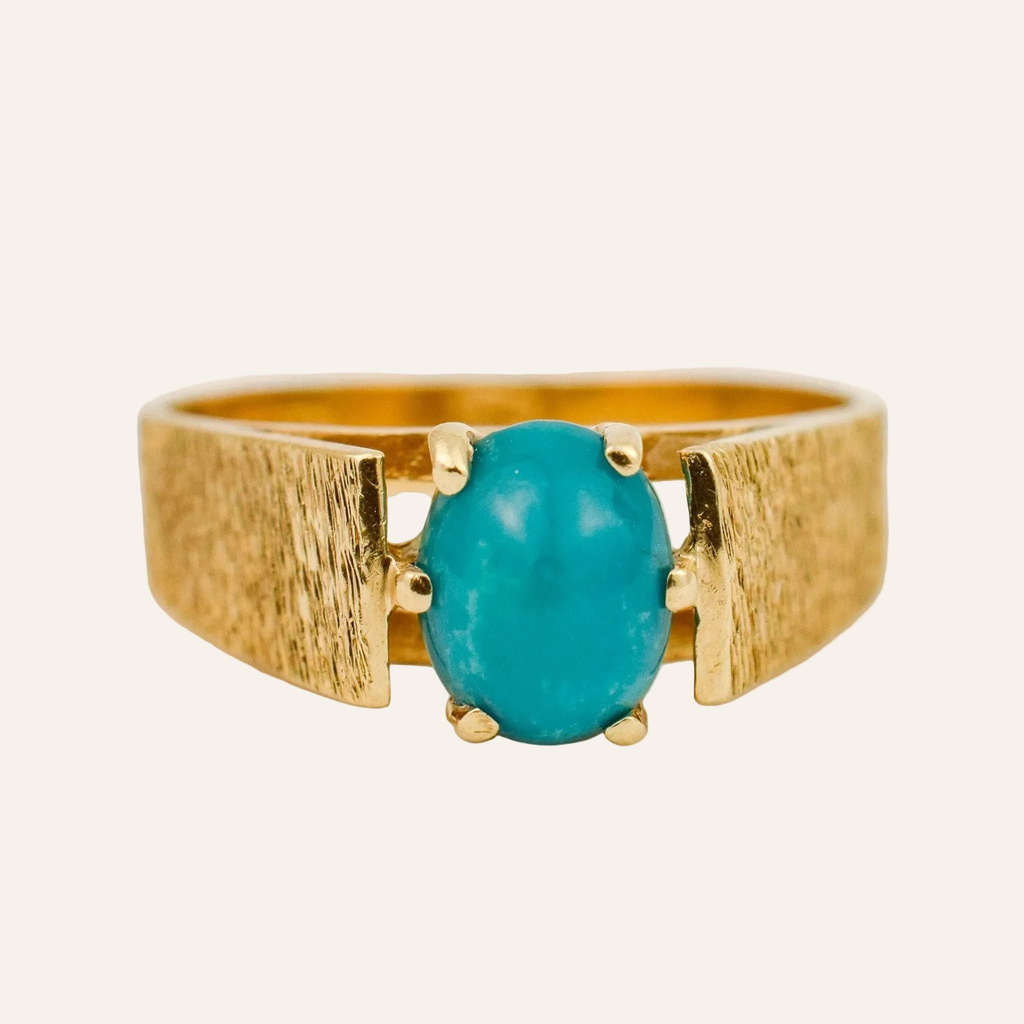 Gold ring with a turquoise stone on a light background