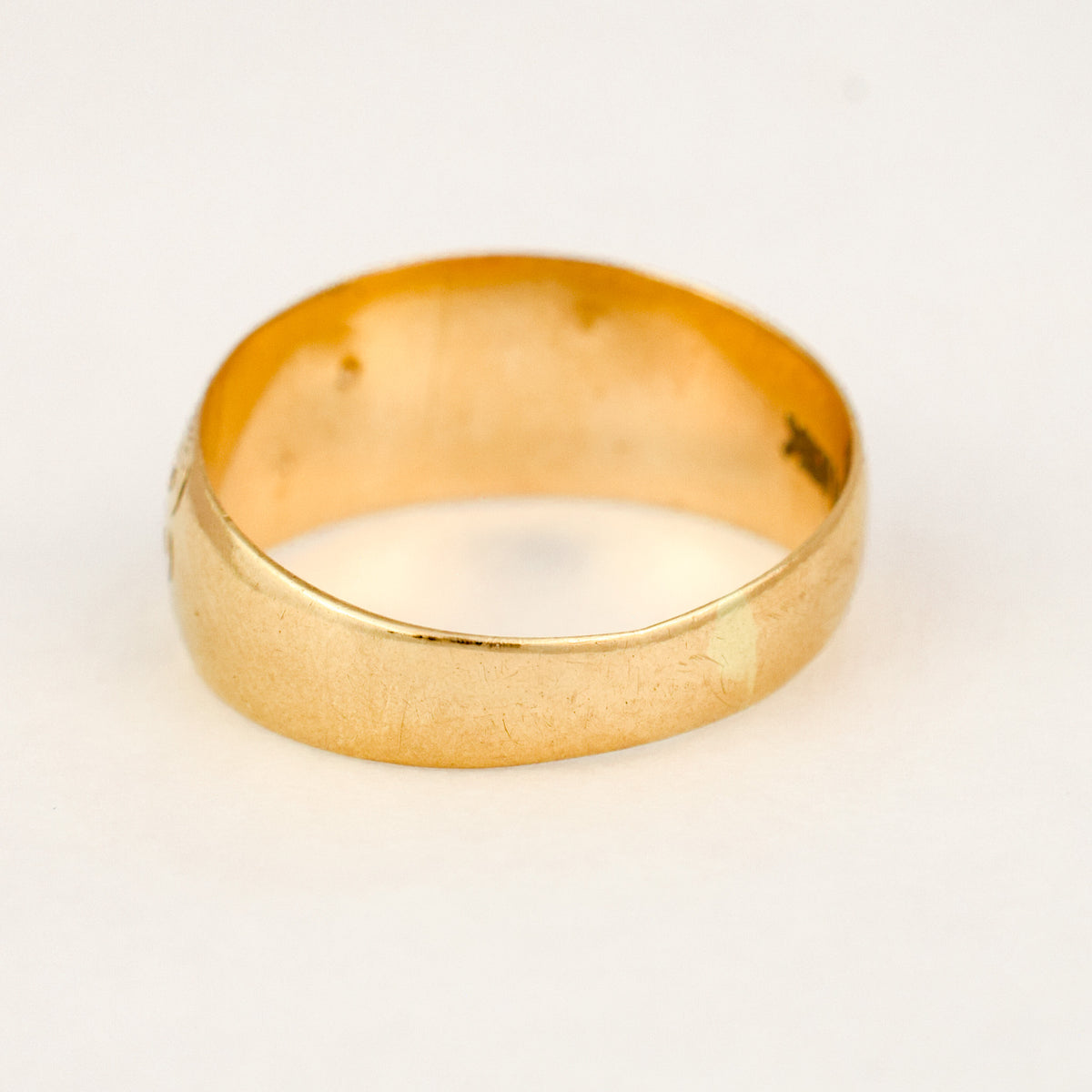 Back view of an antique 10k gold garnet and seed pearl band showing the smooth domed shank.