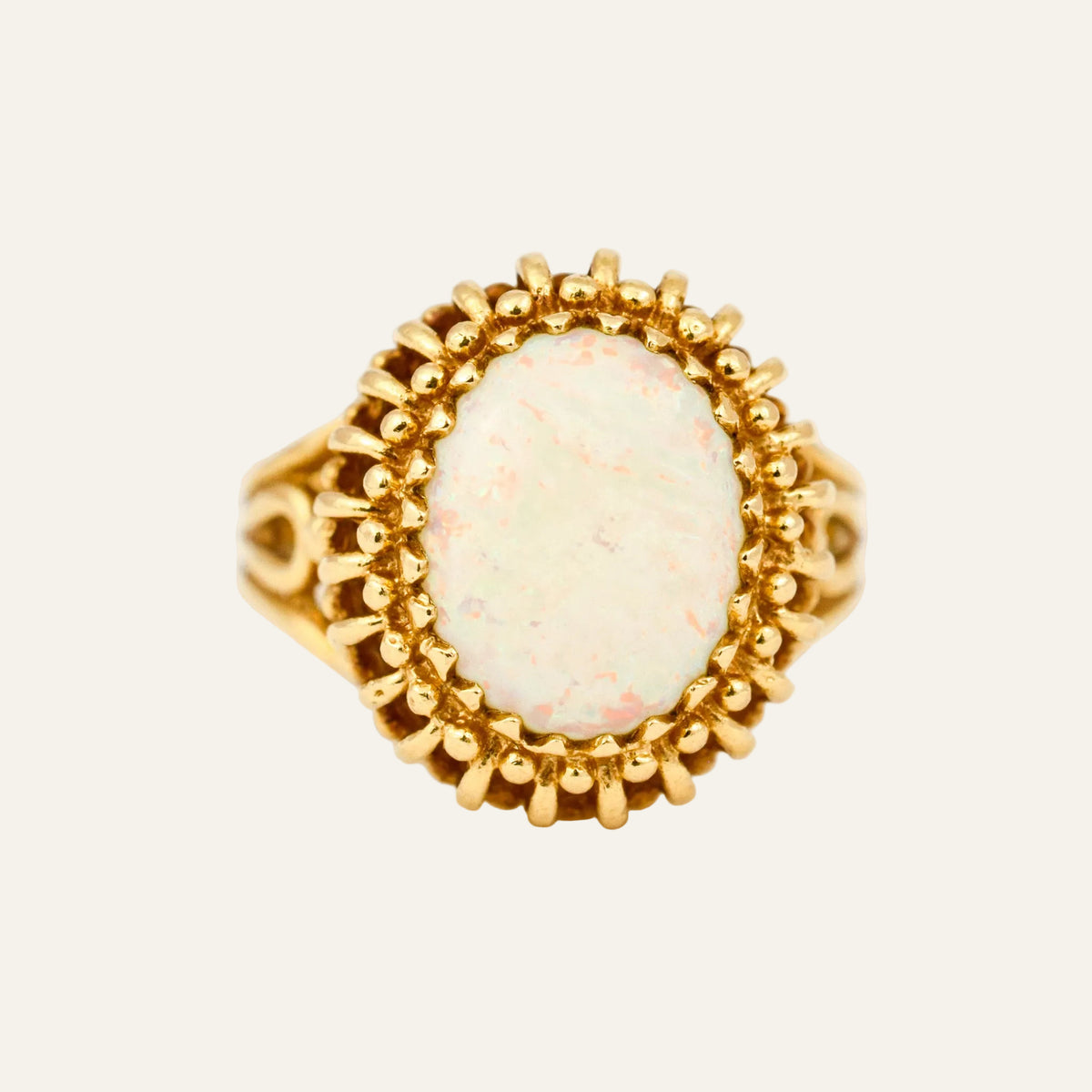 Vintage 14k gold ring with a large opal in a double row of gold beading.