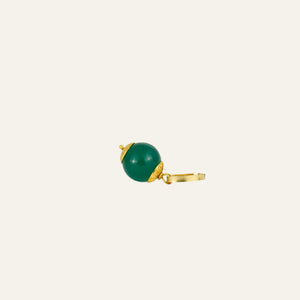 Green bead charm with gold accents on a beige background