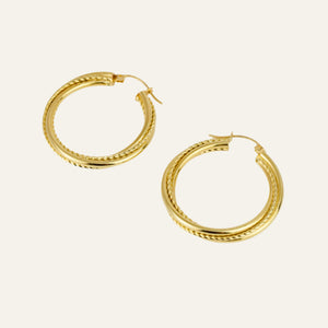 Gold hoop earrings on a light beige background
