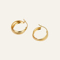 Gold hoop earrings on a light beige background