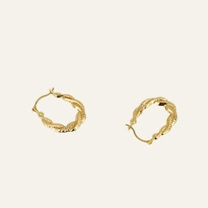 Gold hoop earrings on a light gray background