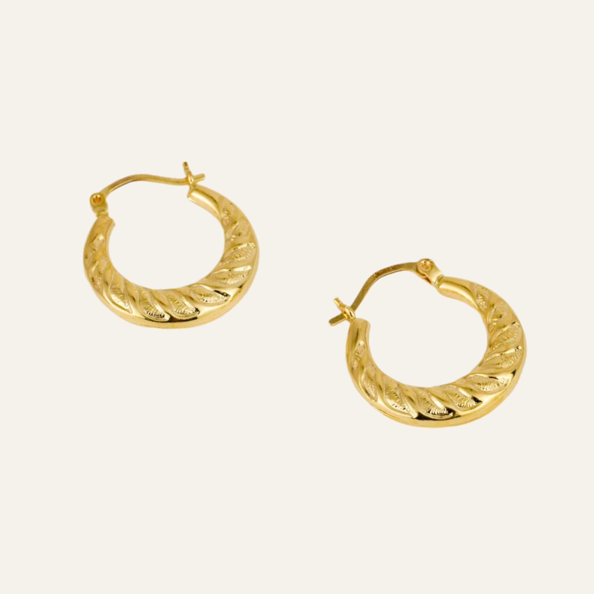 Pair of gold hoop earrings on a light gray background