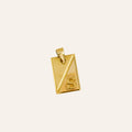 Gold pendant with 'S' on a light beige background