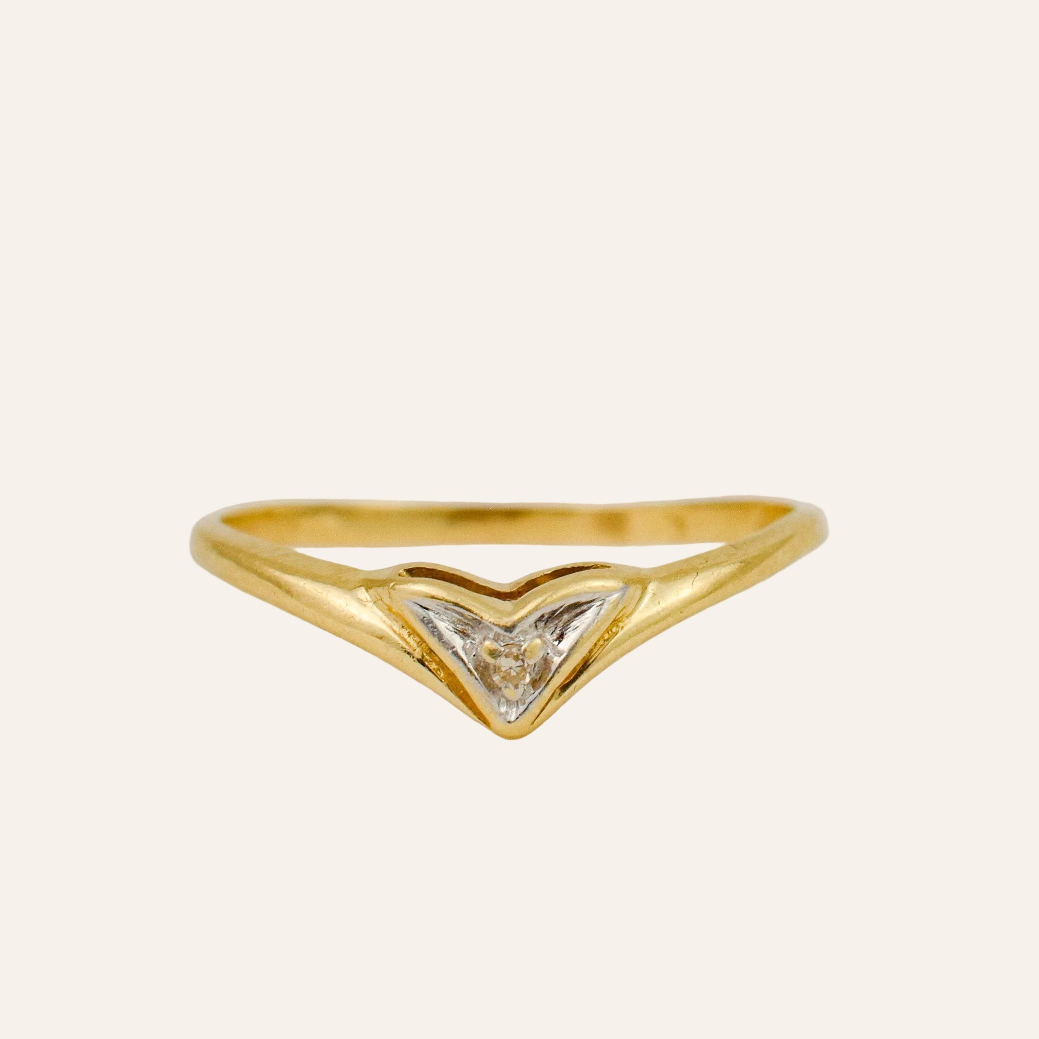 Gold ring with a triangular design on a light gray background