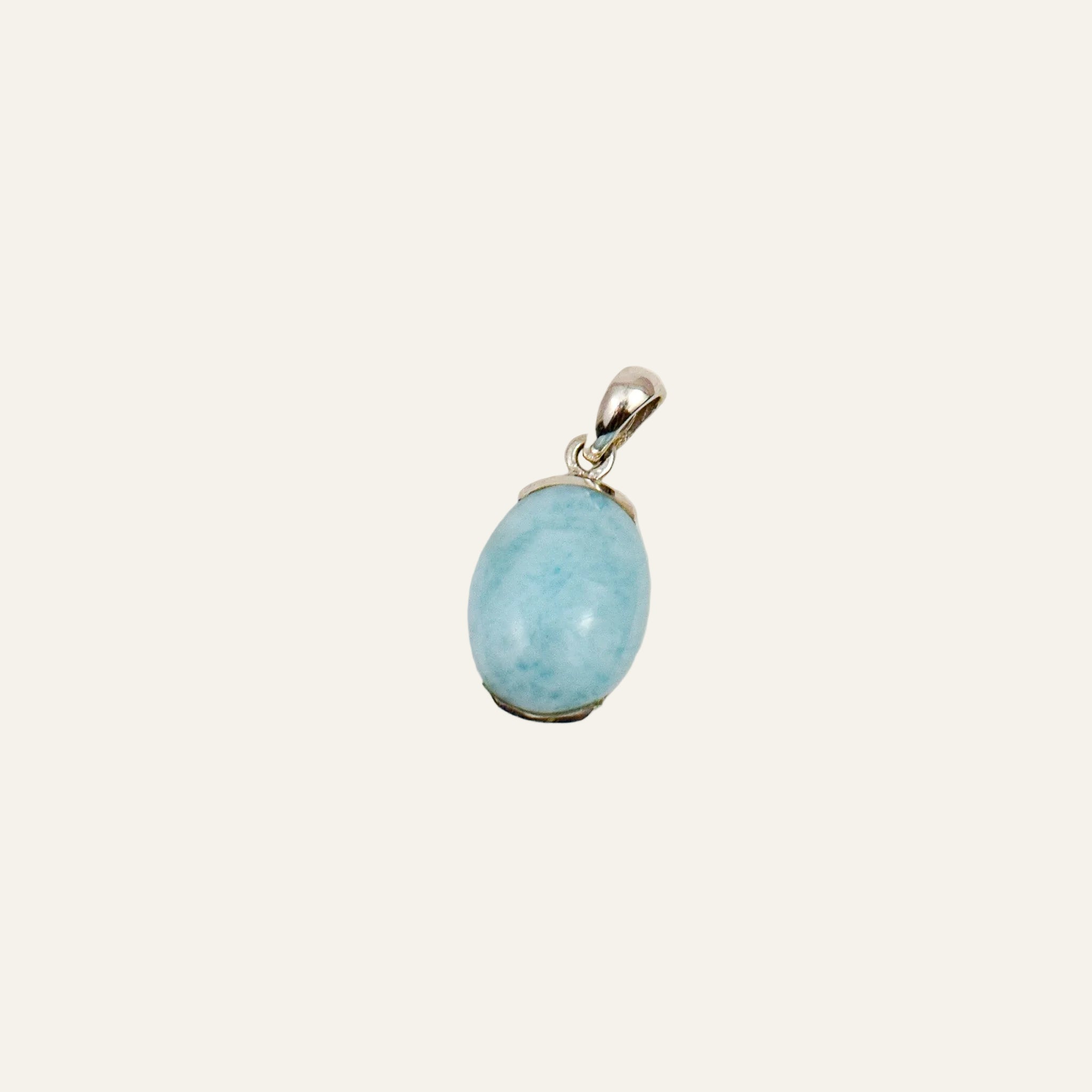 Oval pale blue larimar cabochon prong-set in a 14k white gold pendant