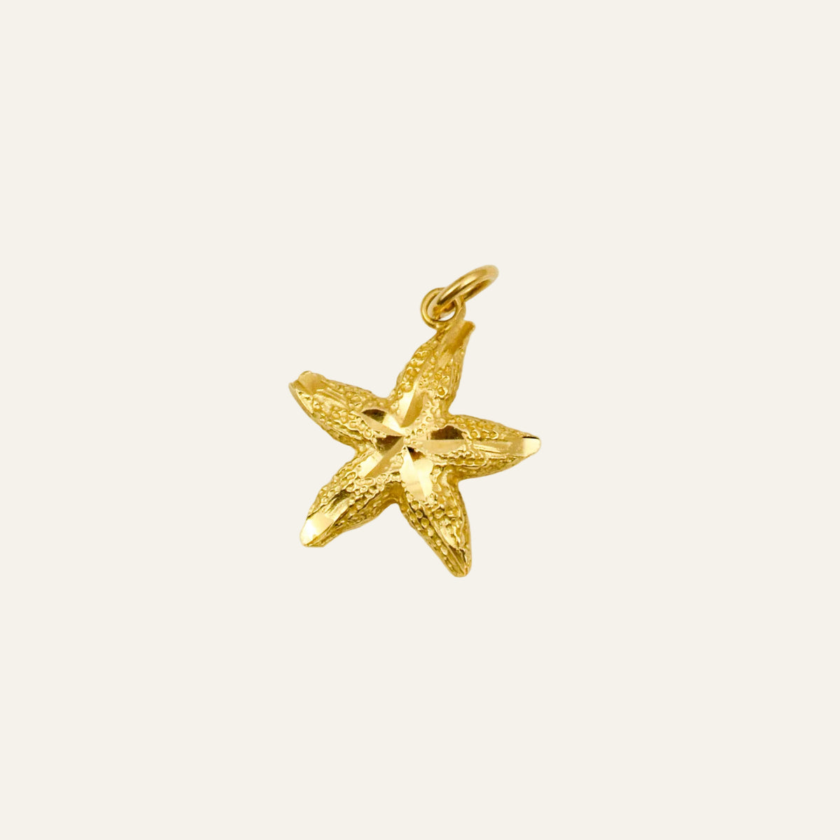 Vintage 10k gold starfish pendant with a finely textured surface and a jump ring at one arm.