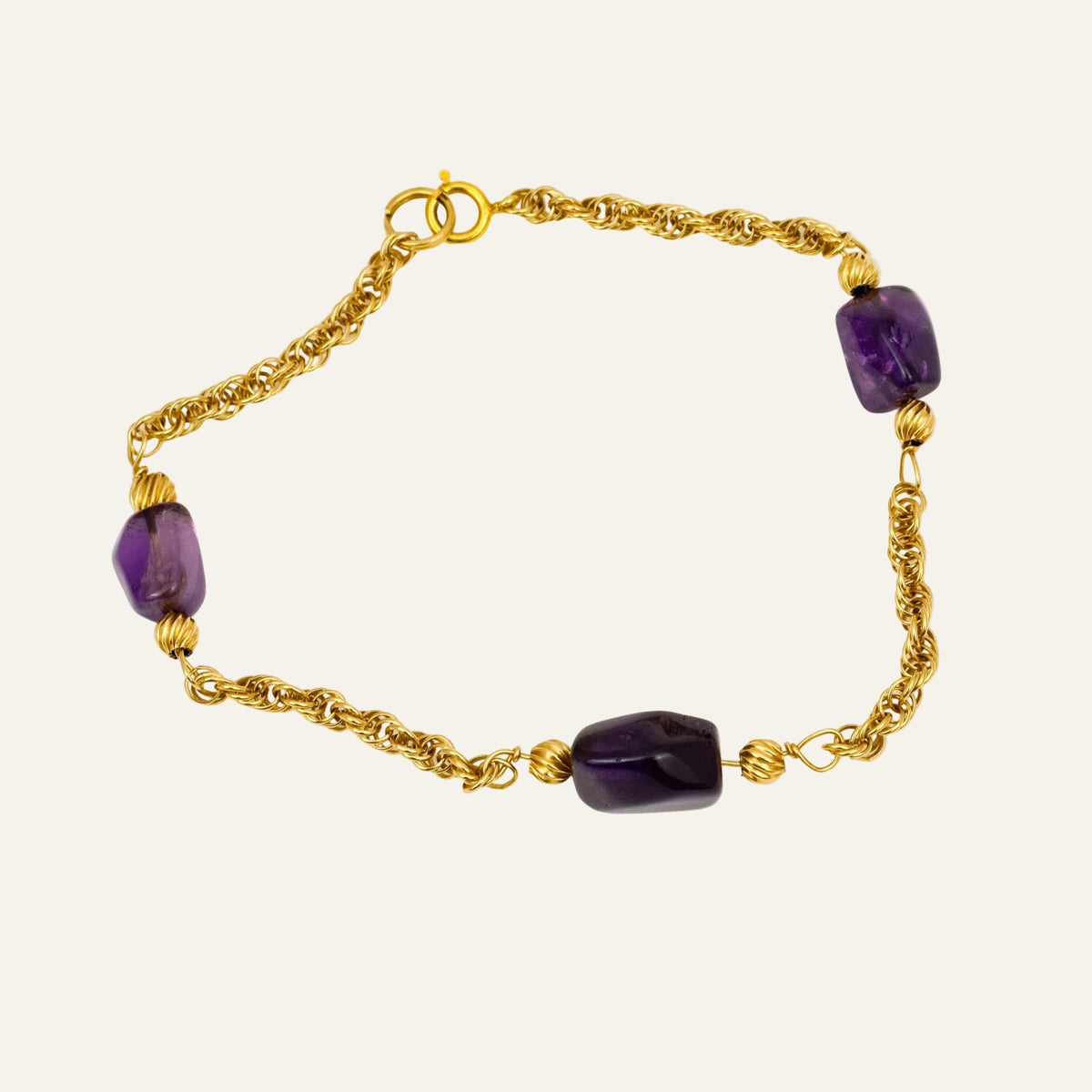 Vintage 14k gold rope chain bracelet with deep purple amethyst stones set at intervals.