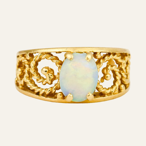 14k yellow gold ring with an opal cabochon in a scrolling openwork mount